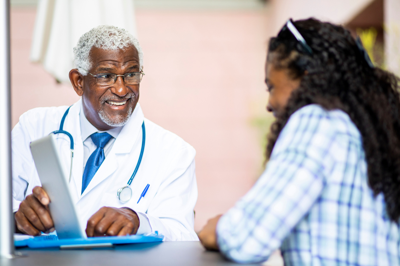 Senior Black Doctor Meeting with Young Black Woman